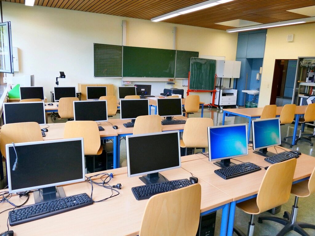 Salle équipée de postes informatiques alignés.