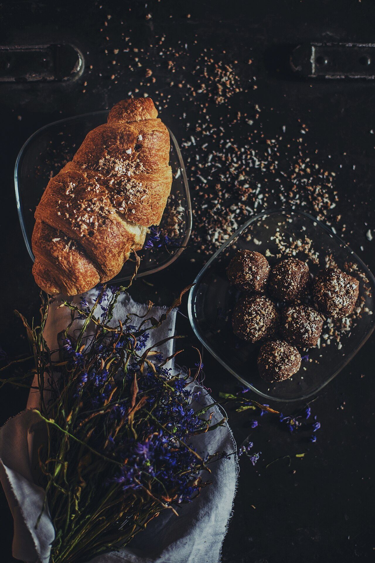 Un croissant et des chocolats disposés sur une ardoise.